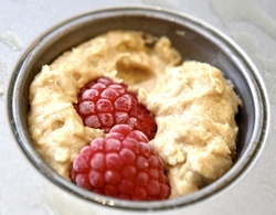 Stikk noen frosne (eller ferske) bringebær i hver muffins
